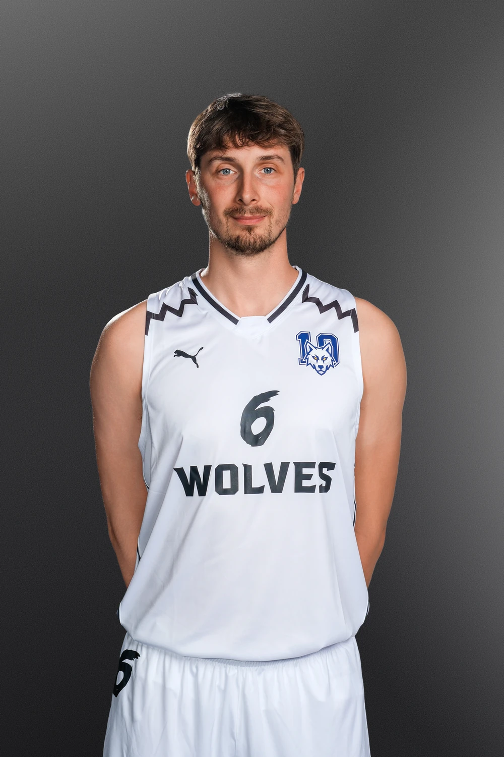 Tomáš Bělohradský v bílém dresu Wolves Radotín na tmavém pozadí